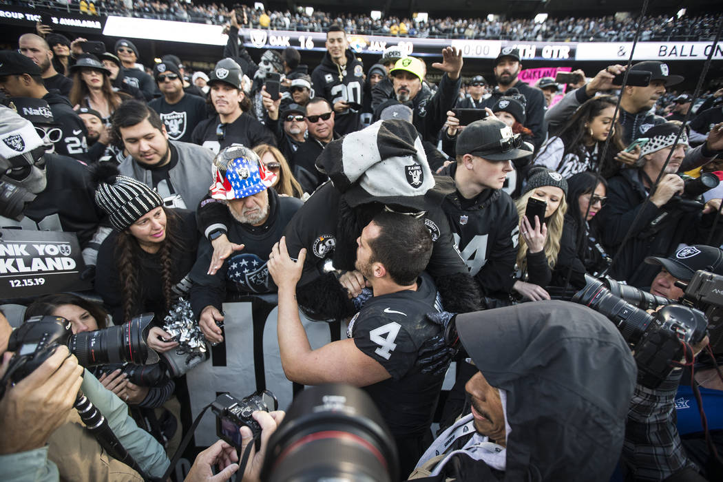 Oakland Raiders quarterback Derek Carr (4) hugs fans in the "Black Hole" after Oakland lost to ...