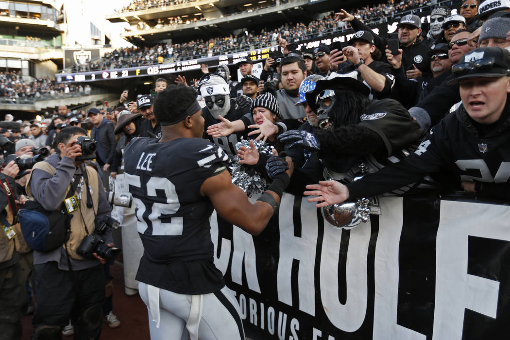 Oakland Raiders middle linebacker Marquel Lee (52) is greeted by fans in "The Black Hole&q ...
