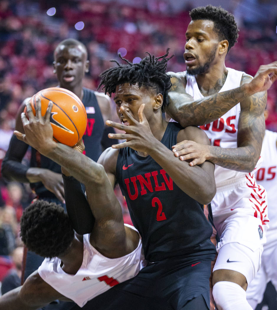 New Mexico Lobos forward Corey Manigault (1, left) battles for a loose ball with UNLV Rebels fo ...
