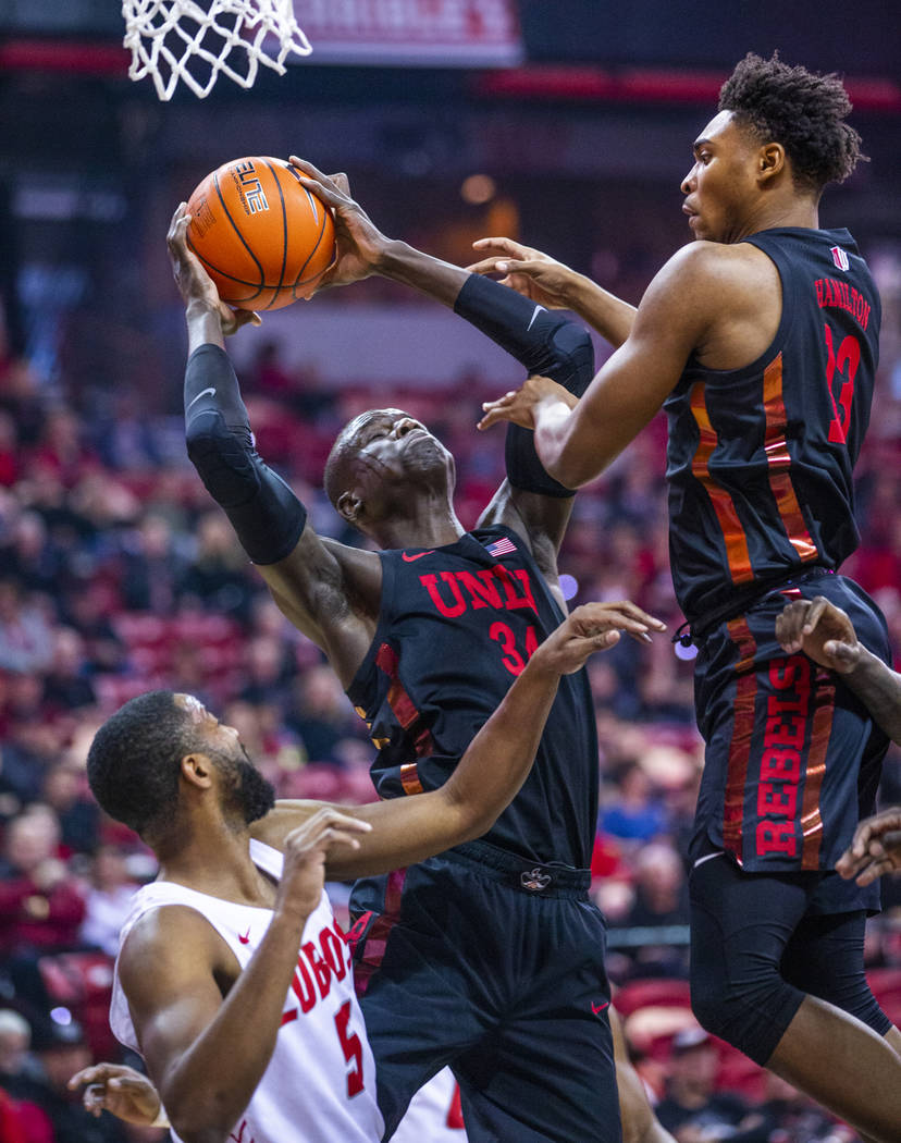 UNLV Rebels forward Cheikh Mbacke Diong (34, center) goes up strong for a shot between New Mexi ...