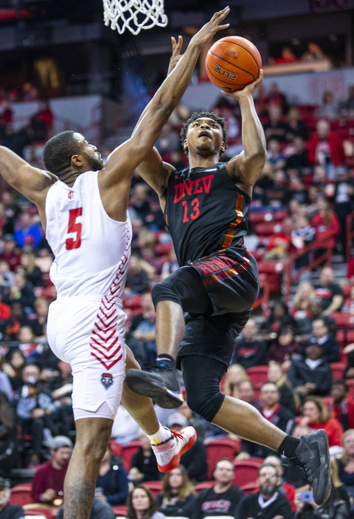 UNLV Rebels guard Bryce Hamilton (13, right) drives on New Mexico Lobos guard JaQuan Lyle (5) d ...