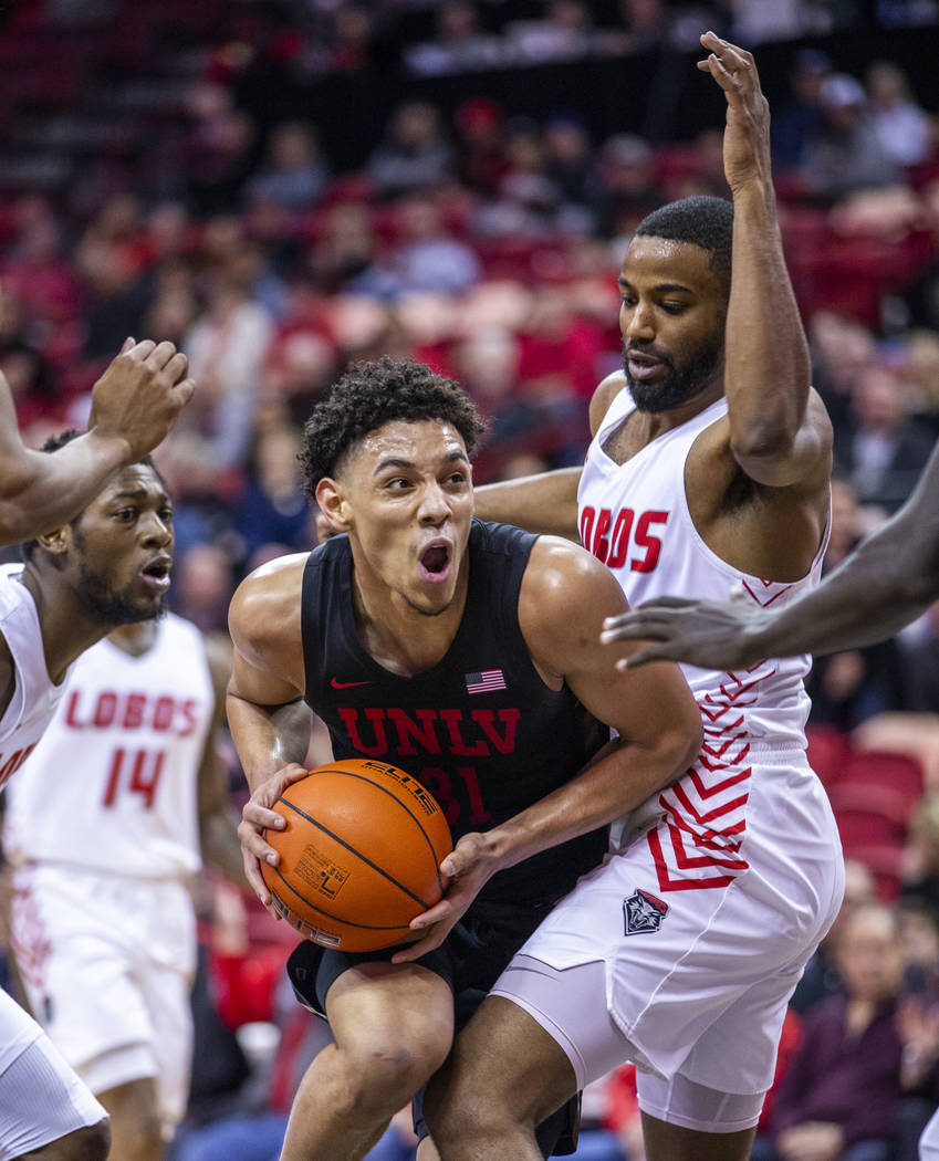 UNLV Rebels guard Marvin Coleman (31, center) battles inside for position on New Mexico Lobos g ...