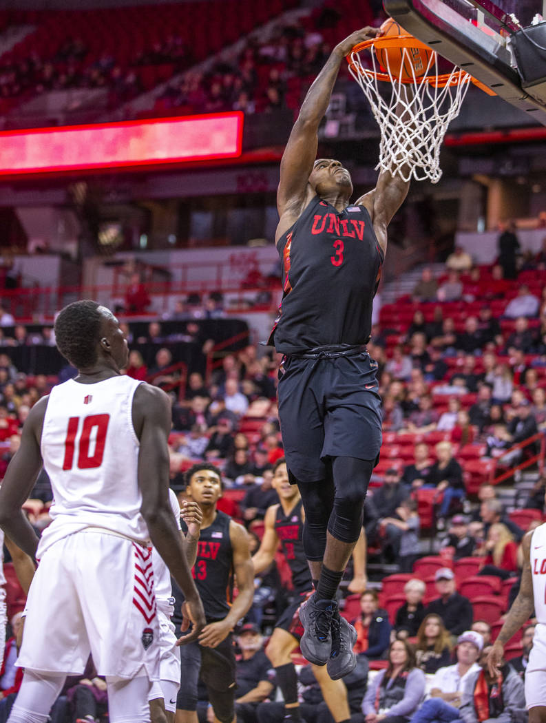 UNLV Rebels guard Amauri Hardy (3, right) lays in the ball over New Mexico Lobos guard Makuach ...