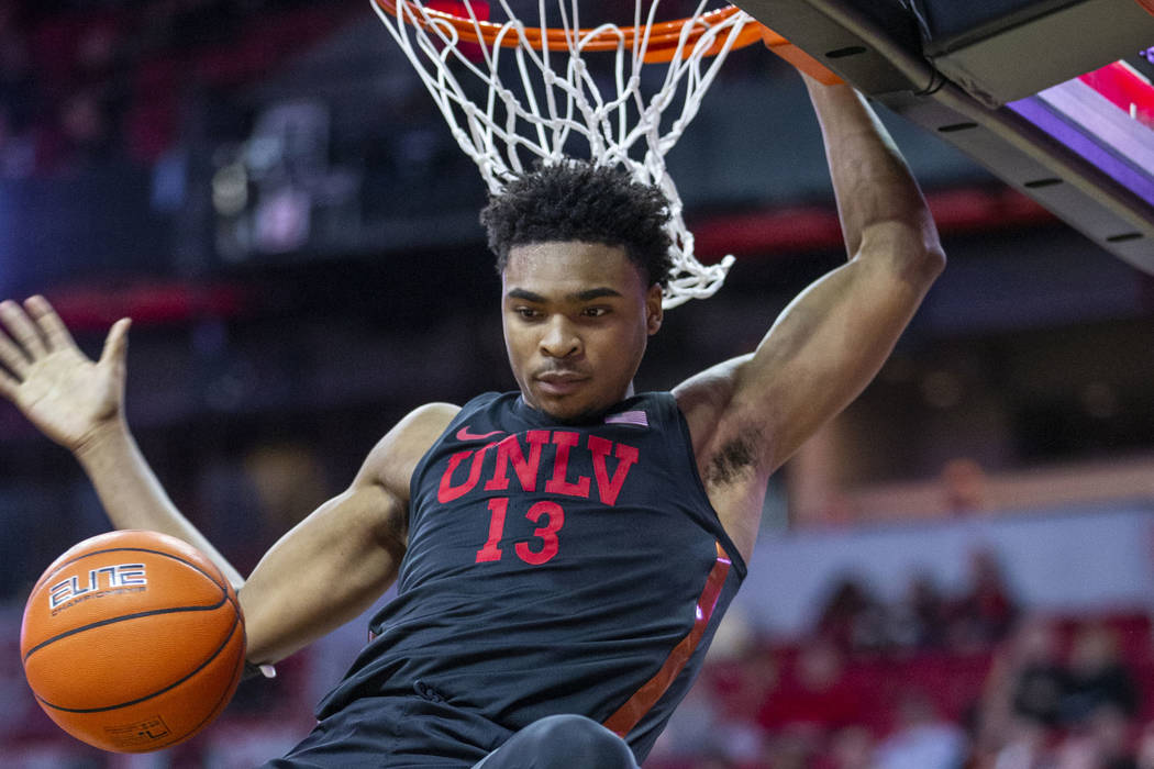 UNLV Rebels guard Bryce Hamilton (13,) drives on dunks the ball over New Mexico Lobos forward C ...