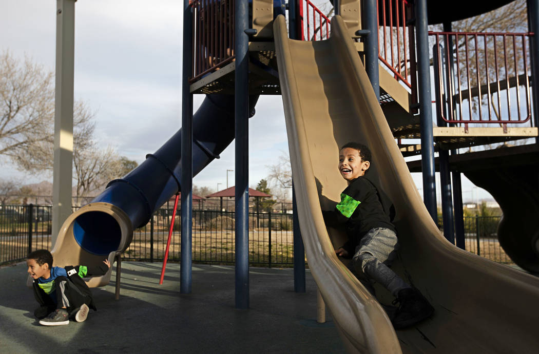 Twins Manny Drexler and Sammy Drexler, 5, play on the slides at Justice Myron E. Leavitt & ...