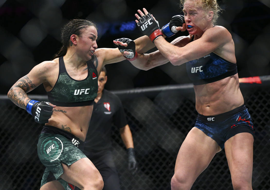 Holly Holm, right, takes a hit from Raquel Pennington during their bantamweight bout at UFC 246 ...