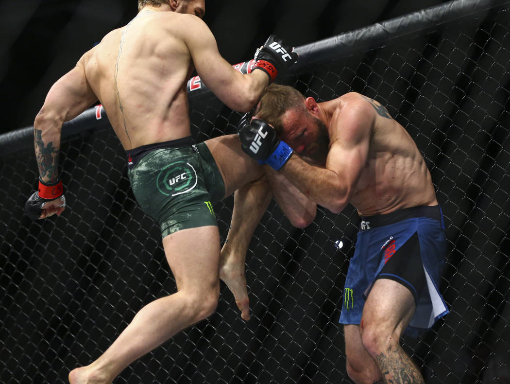 Conor McGregor, left, fights Donald "Cowboy" Cerrone during their welterweight bout a ...