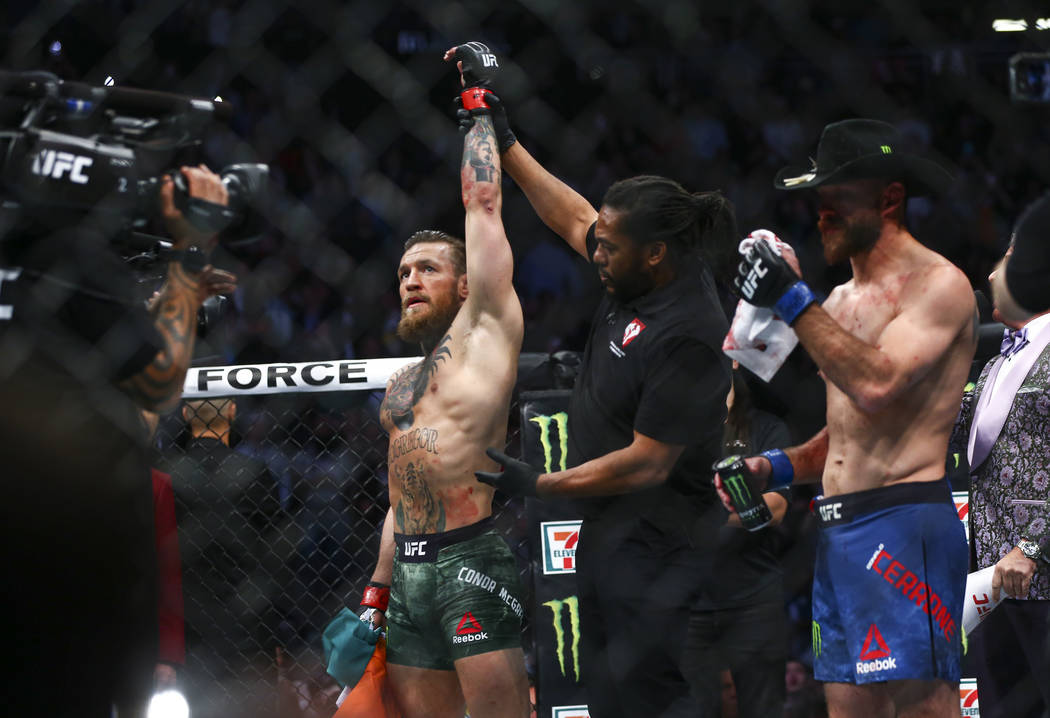 Conor McGregor, left, celebrates his victory over Donald "Cowboy" Cerrone via technic ...