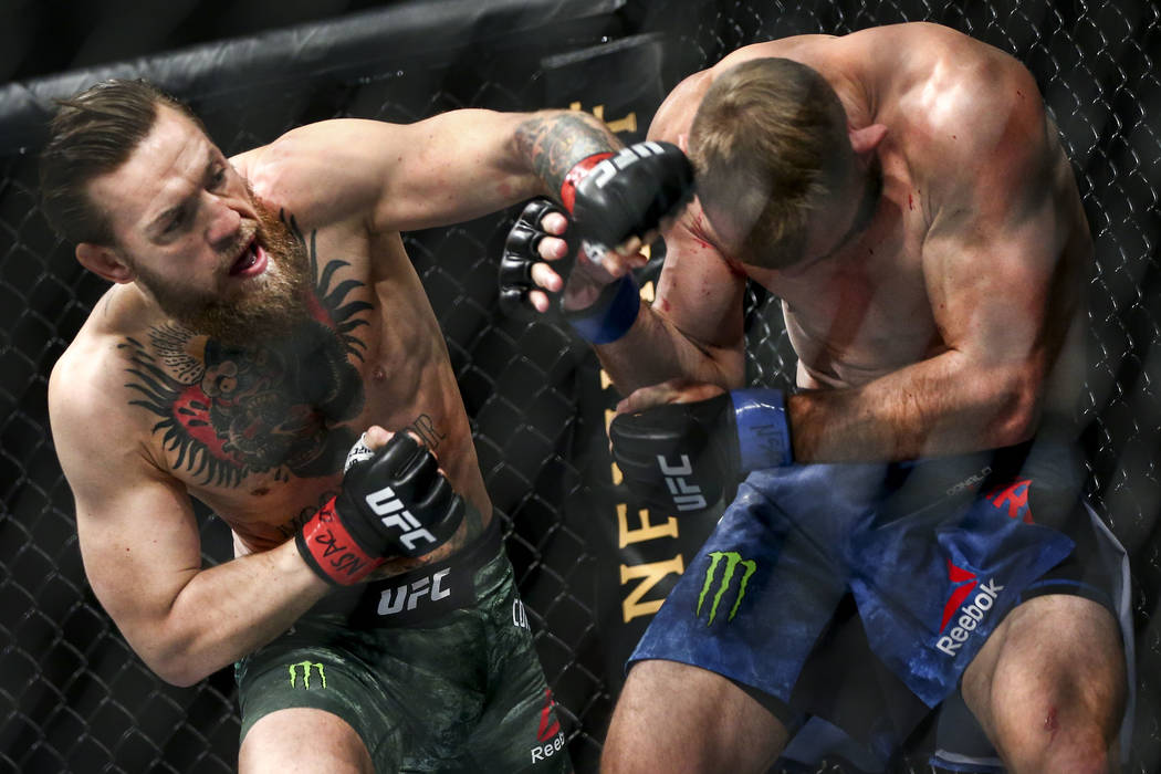 Conor McGregor, left, fights Donald "Cowboy" Cerrone during their welterweight bout a ...