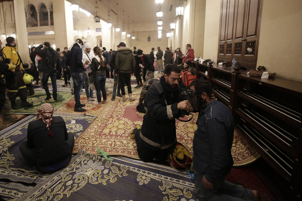 An anti-government protester receives treatment after confrontation with Lebanese riot police i ...