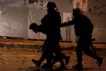 Lebanese police arrest an anti-government protester after dispersing a protest in Beirut, Leban ...