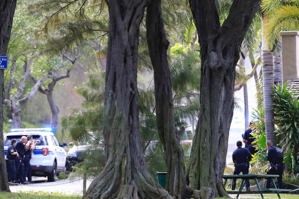 Police surround a house where a shooting suspect is believed to be in Honolulu, Sunday, Jan. 19 ...