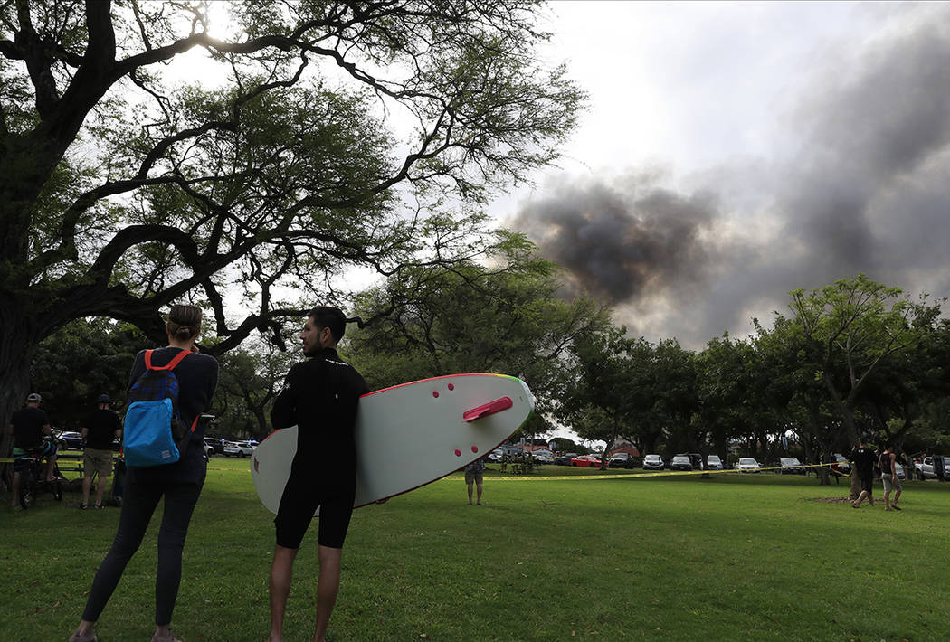 Aina Haina resident Kai Ohashi, right, and Waikiki resident Lucy Taylor observe billowing smoke ...