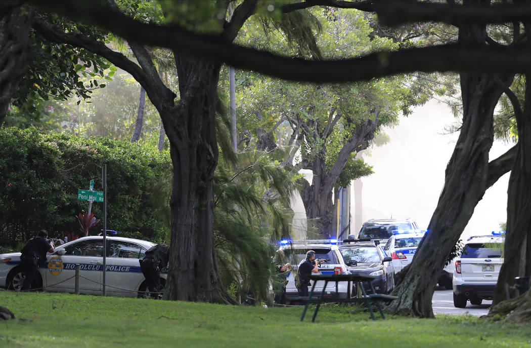 Honolulu police take up defensive positions with their weapons after a shooting and domestic in ...