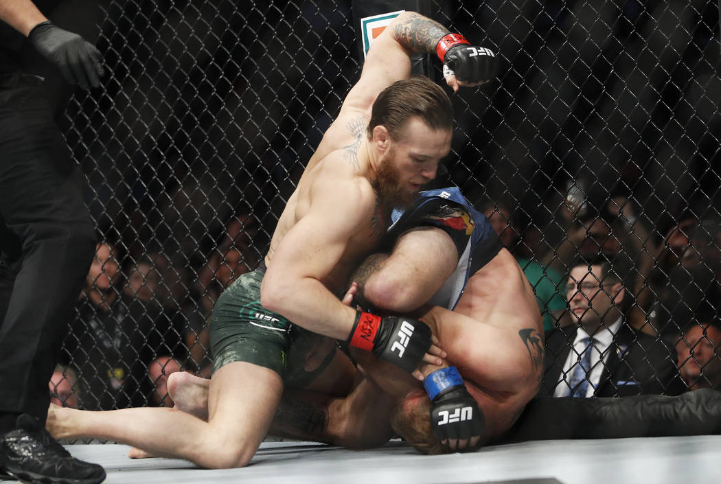 Conor McGregor, left, fights Donald "Cowboy" Cerrone during a UFC 246 welterweight mi ...