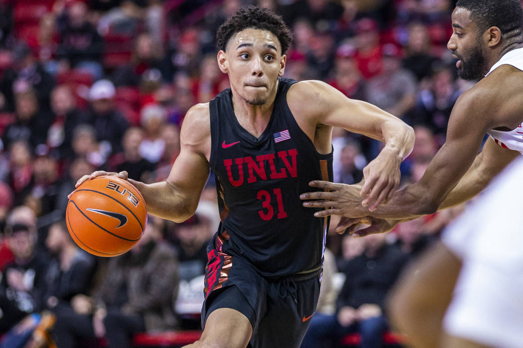 UNLV Rebels guard Marvin Coleman (31, center) drives the lane versus New Mexico Lobos guard JaQ ...