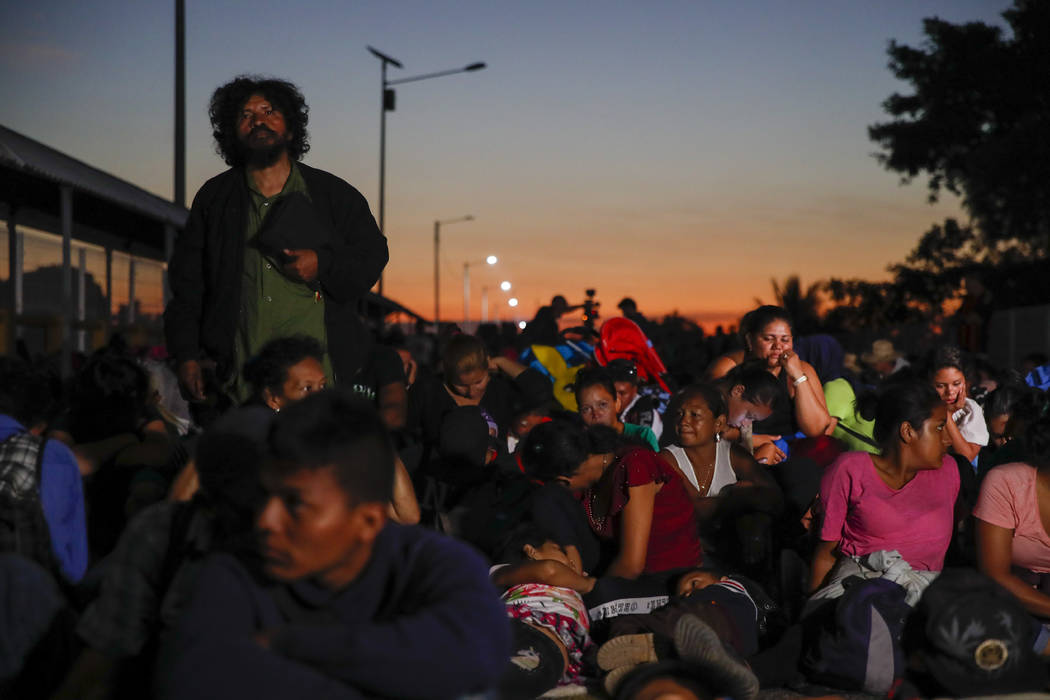 Migrants gather at the bridge spanning the Suchiate River in Tecun Uman, Guatemala, Monday, Jan ...