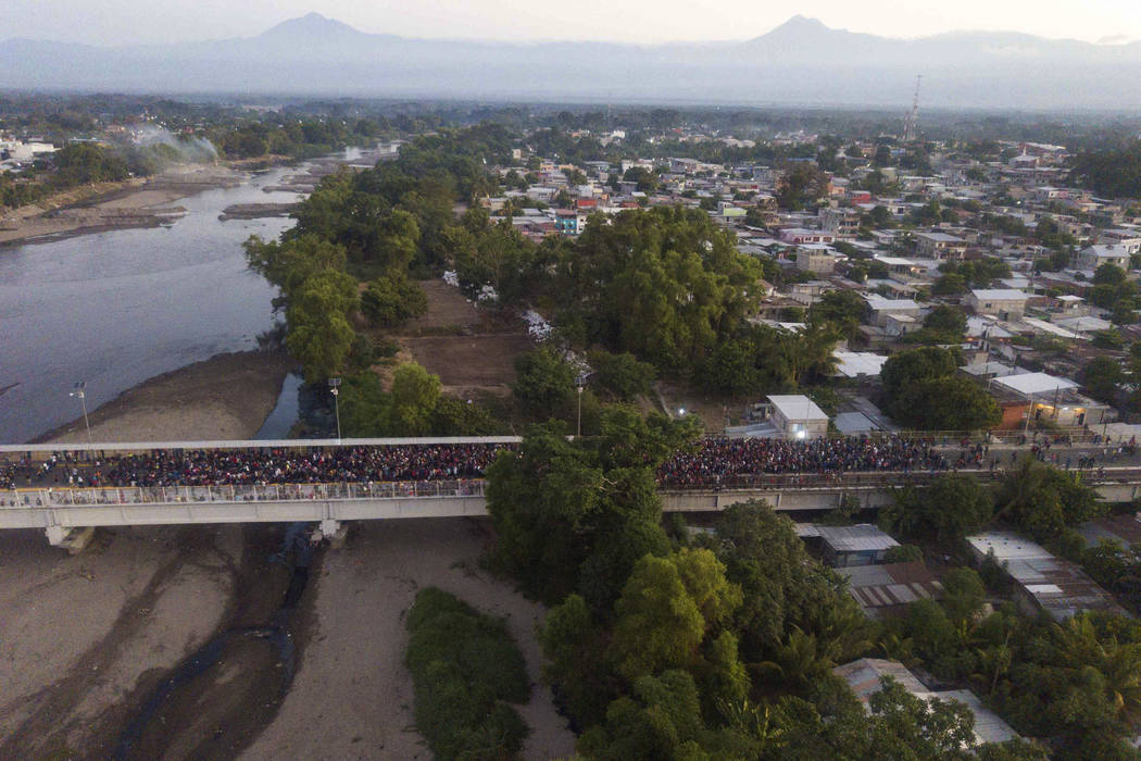 Migrants gather at the bridge spanning the Suchiate River in Tecun Uman, Guatemala, Monday, Jan ...