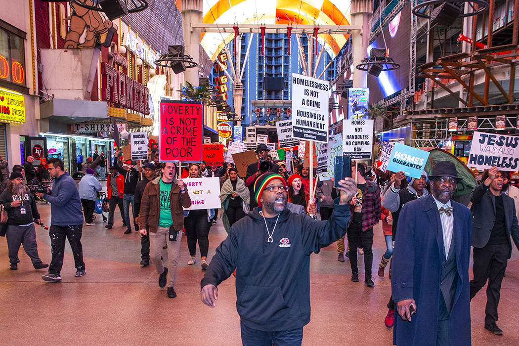 Local activists march through the Fremont Experience following a rally at the Las Vegas City Ha ...