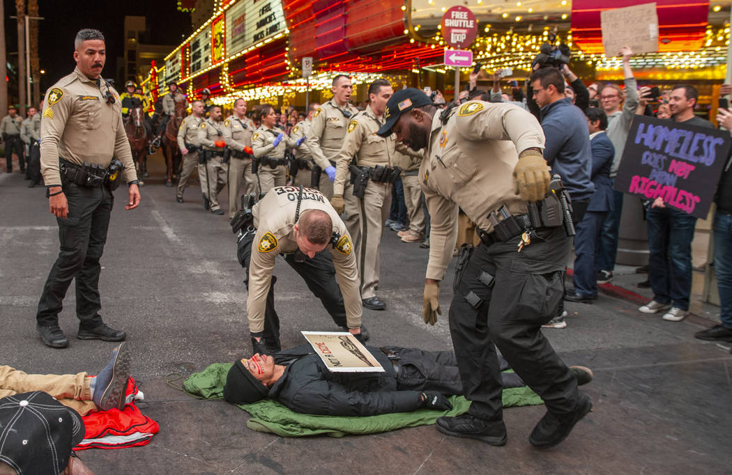 Las Vegas Metropolitan Police officers move in to arrest local activists blocking Casino Center ...