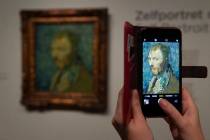 A journalist takes a picture of the previously contested painting by Dutch master Vincent van G ...