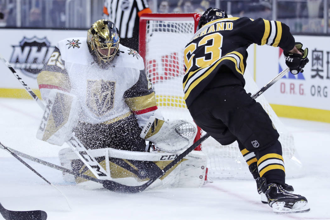 Vegas Golden Knights goaltender Marc-Andre Fleury, left, makes a save on a shot by Boston Bruin ...