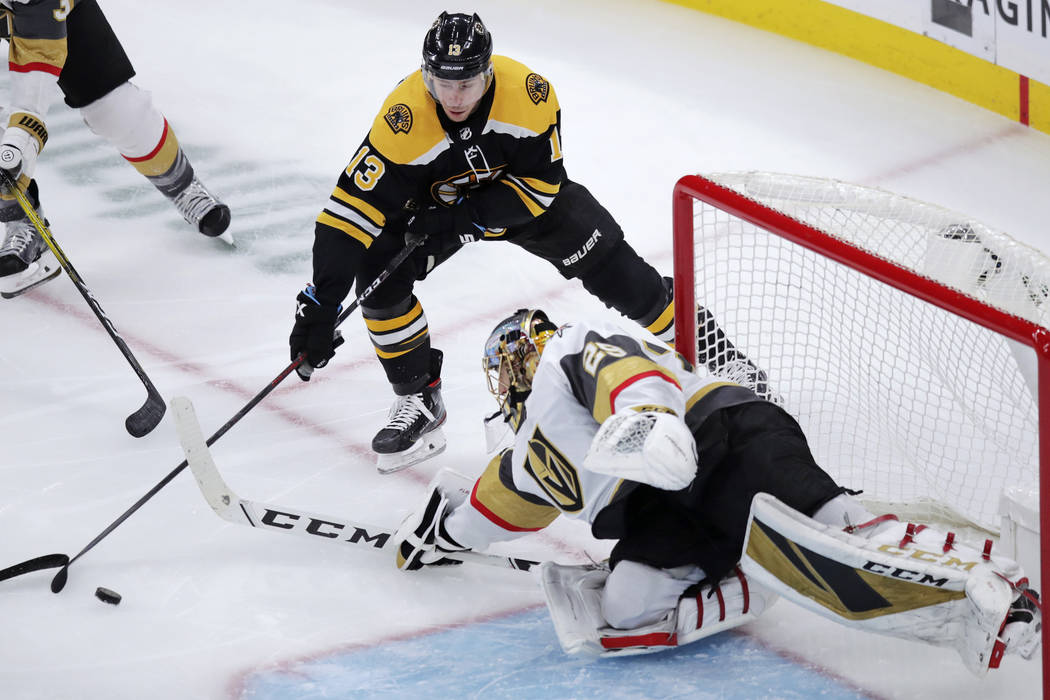 Vegas Golden Knights goaltender Marc-Andre Fleury, right, reaches for the puck against Boston B ...