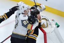 Boston Bruins left wing Brad Marchand is slammed into the goal by Vegas Golden Knights defensem ...