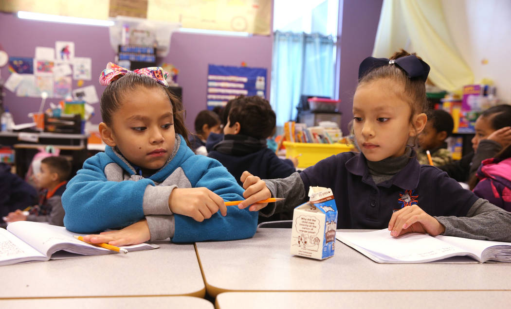 E'liana Trujillo borrows a pencil from Maryah Villezcas in Shamika Abbott's first grade class a ...