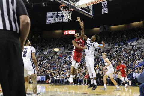 UNLV Rebels' Bryce Hamilton (13) goes to the basket against UNR's Lindsey Drew (14) during the ...