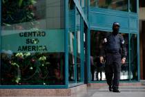 A Venezuelan security officer guards the entrance, after other officers entered the building wh ...
