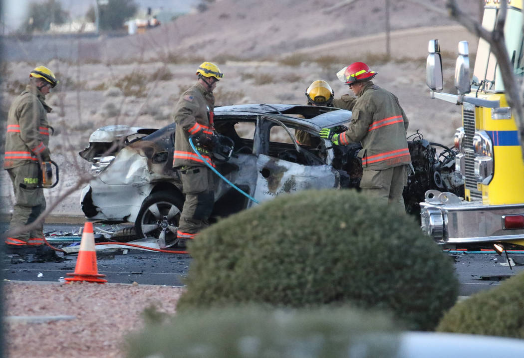 Clark County firefighters work at a three-vehicle crash site where one motorist was killed and ...