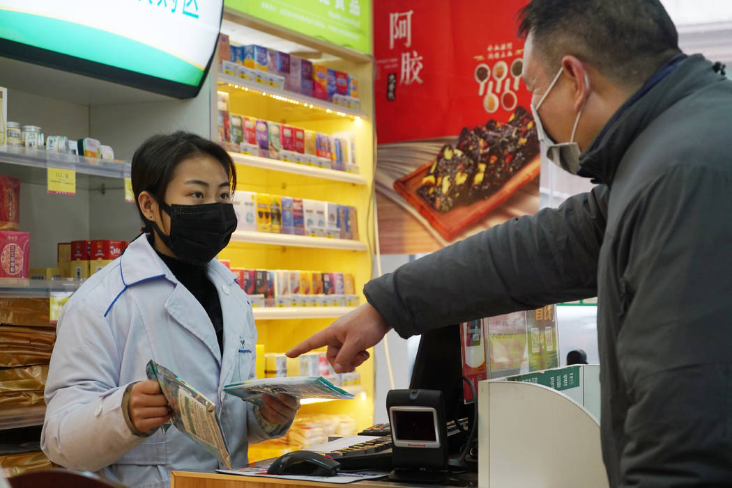 Staff sell masks at a Yifeng Pharmacy in Wuhan, Chin, Wednesday, Jan. 22, 2020. Pharmacies in W ...