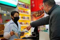 Staff sell masks at a Yifeng Pharmacy in Wuhan, Chin, Wednesday, Jan. 22, 2020. Pharmacies in W ...