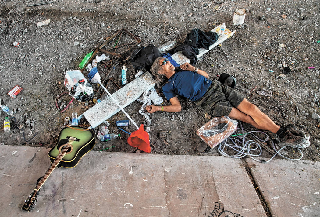 A homeless individual takes a nap beside some possessions below the Flamingo Road overpass on T ...