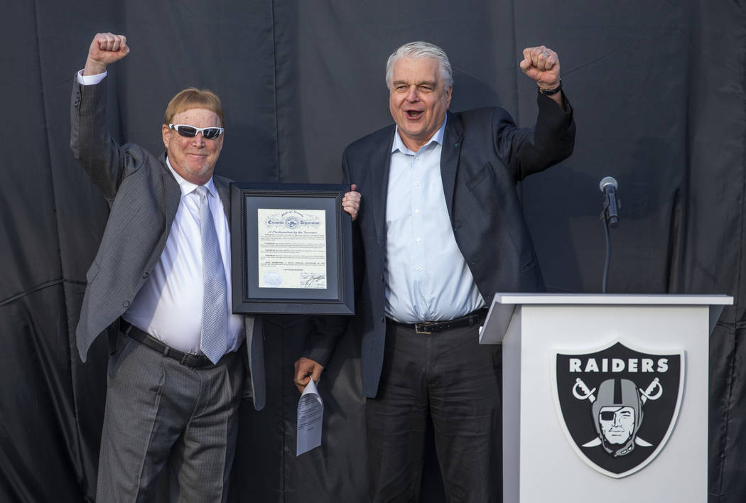 Raiders owner Mark Davis, left, cheers along with Nevada Gov. Steve Sisolak after awarding him ...
