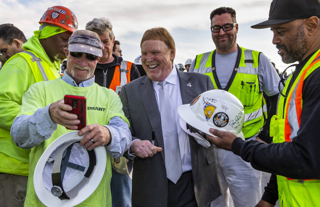 Construction worker David Geene, left, attempts to take a selfie with Raiders owner Mark Davis ...