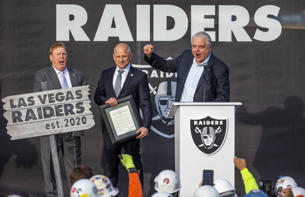 Nevada Gov. Steve Sisolak, right, helps lead a cheer beside Raiders President Marc Badain and o ...