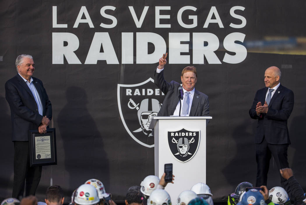 Nevada Gov. Steve Sisolak, left, looks to Raiders owner Mark Davis who addresses the crowd besi ...