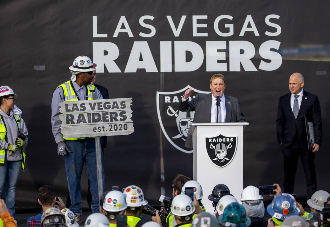 Raiders owner Mark Davis, center, addresses the crowd beside team president Marc Badain, right, ...