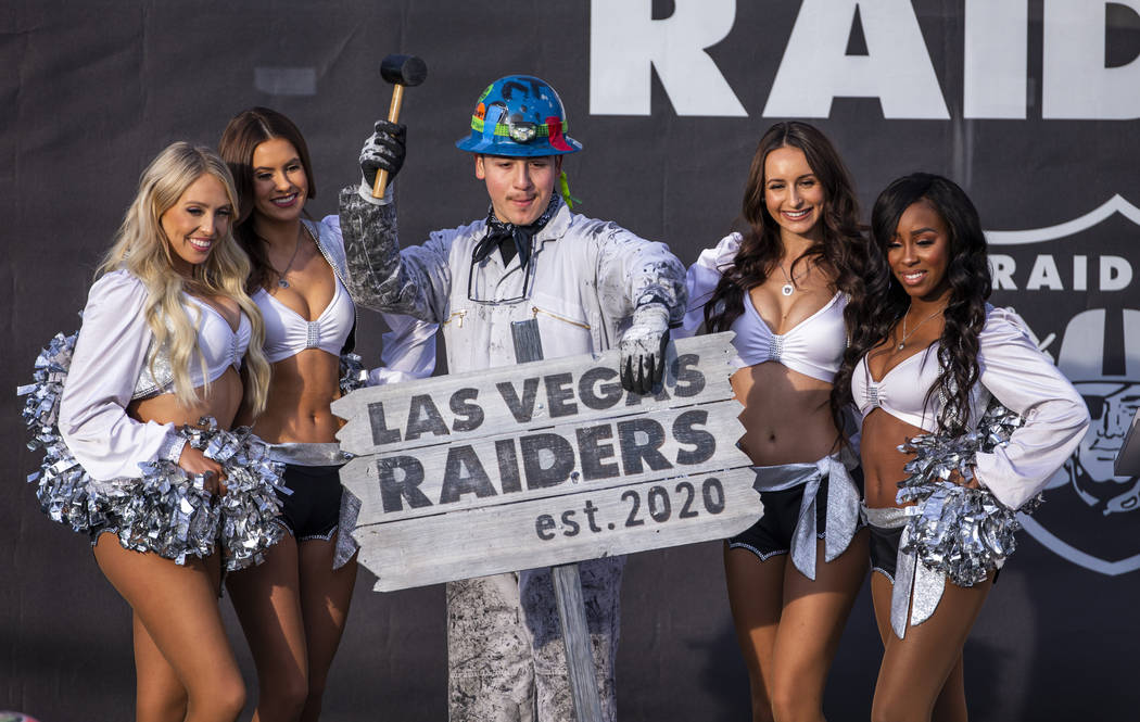 Painter Angel Ayala poses with a hammer between the Raiderettes during a special announcement a ...