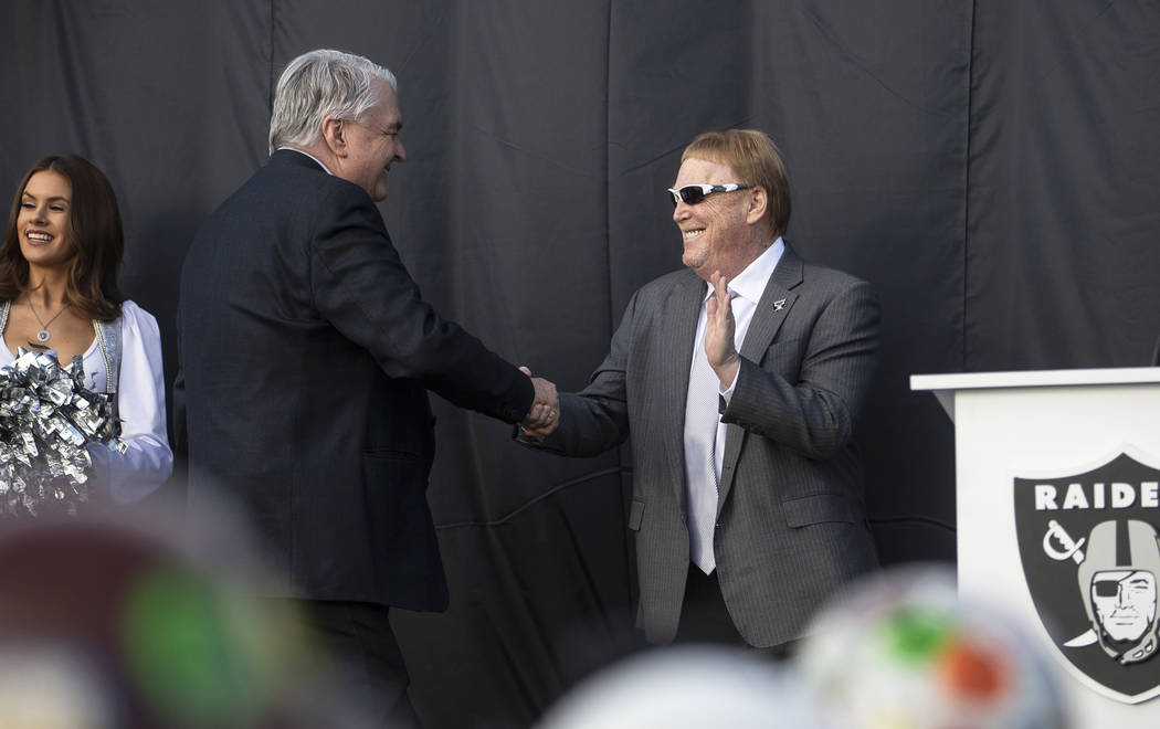 Nevada Gov. Steve Sisolak, center, shakes hands with Raiders owner Mark Davis during a special ...
