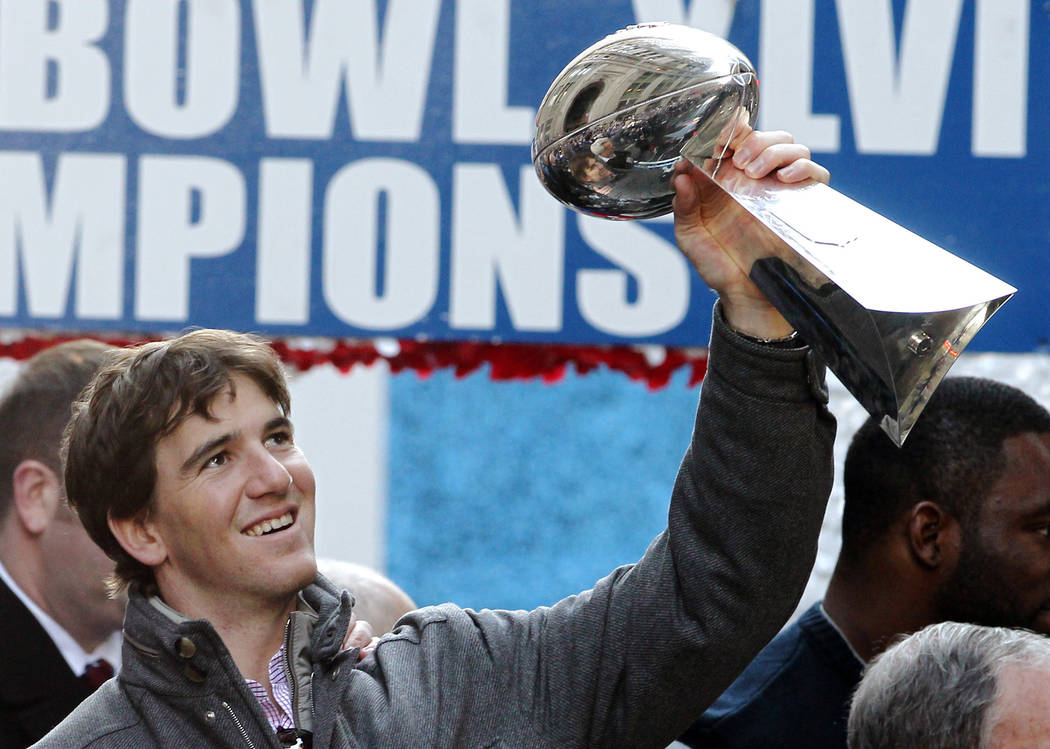 File-This Feb. 7, 2012, file photo shows New York Giants quarterback Eli Manning holding up the ...