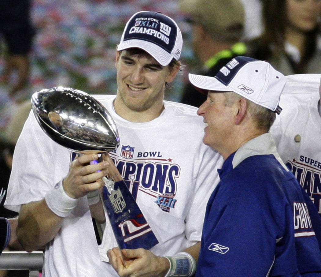 File-This Feb. 3, 2008, file photo shows New York Giants quarterback Eli Manning, left, and his ...