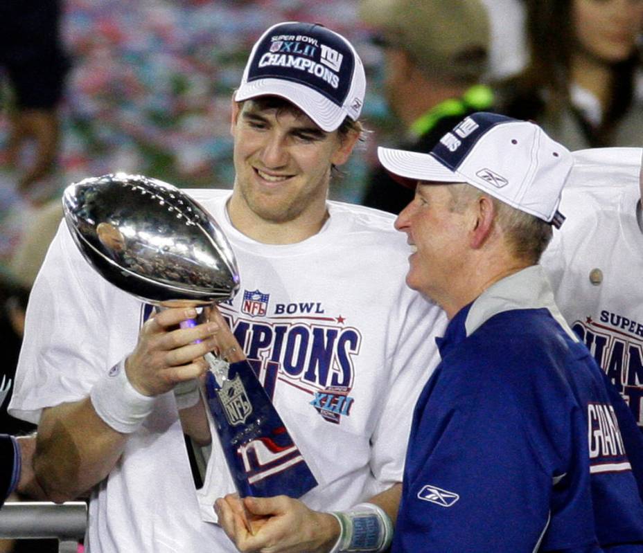 File-This Feb. 3, 2008, file photo shows New York Giants quarterback Eli Manning, left, and his ...