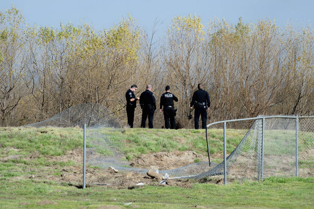Corona Police officers survey the site where an airplane crashed and burned in a ditch next to ...