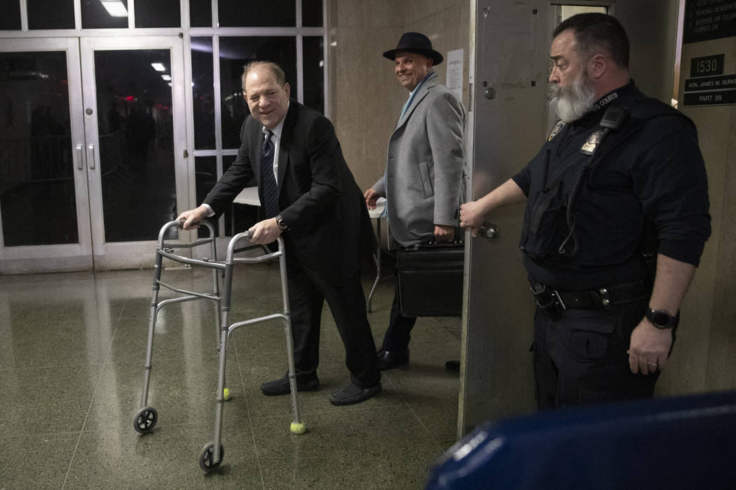 A court officer holds the door as Harvey Weinstein, left, leaves the courtroom with his attorne ...