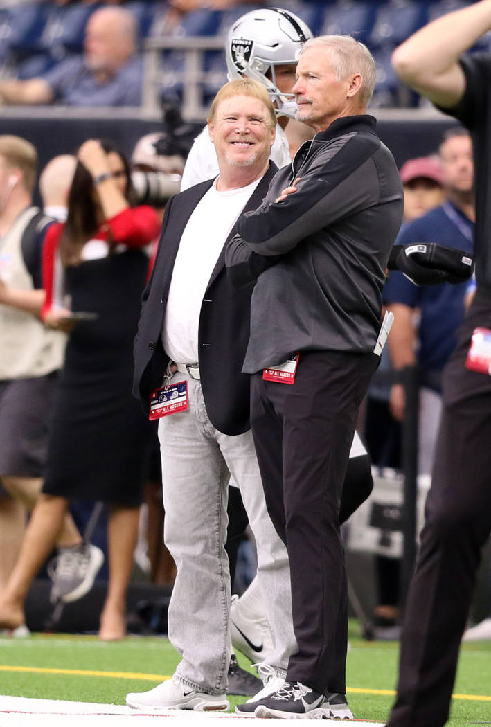 Oakland Raiders owner Mark Davis, left, and general manager Mike Mayock meet on the field prior ...
