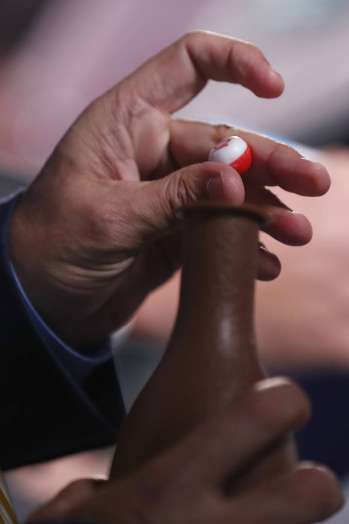 Stakes coordinator Eric Friedman draws a number from a bottle during the draw for the Pegasus W ...