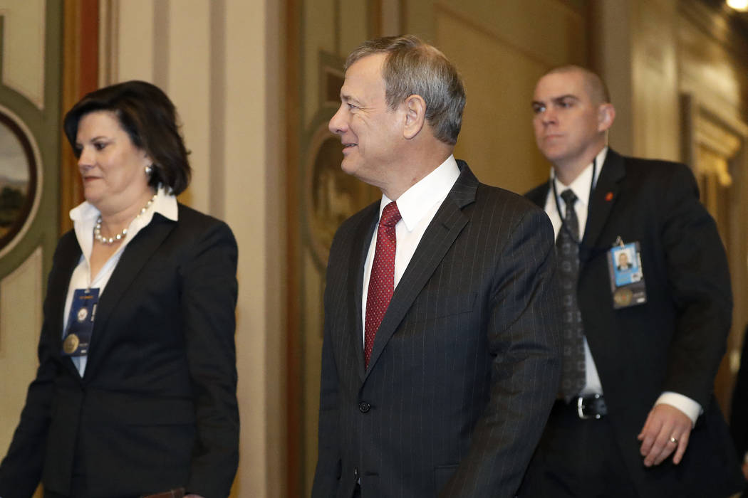 Supreme Court Chief Justice John Roberts, center, arrives at the Capitol in Washington for the ...
